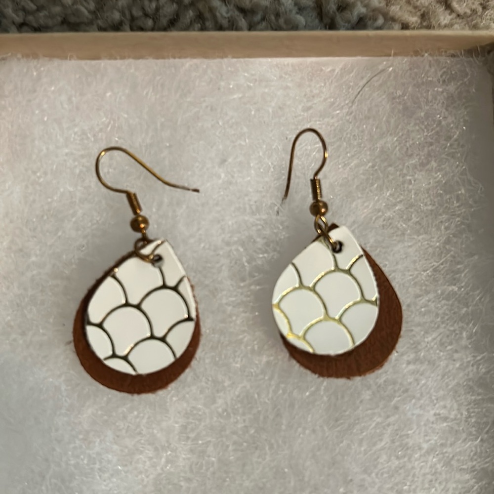 White earrings with gold design.
